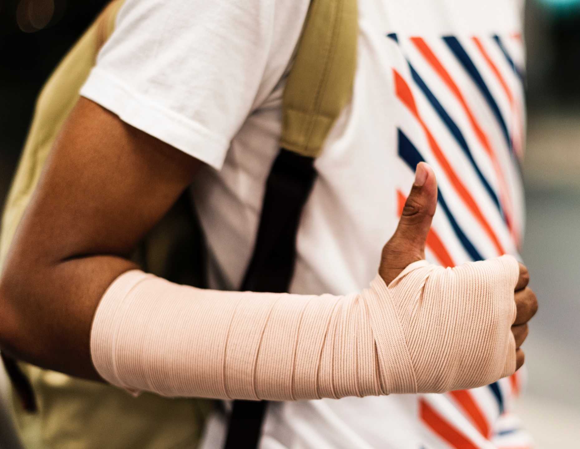 Close-up van gewonde arm voor mobiele app om incidenten te melden