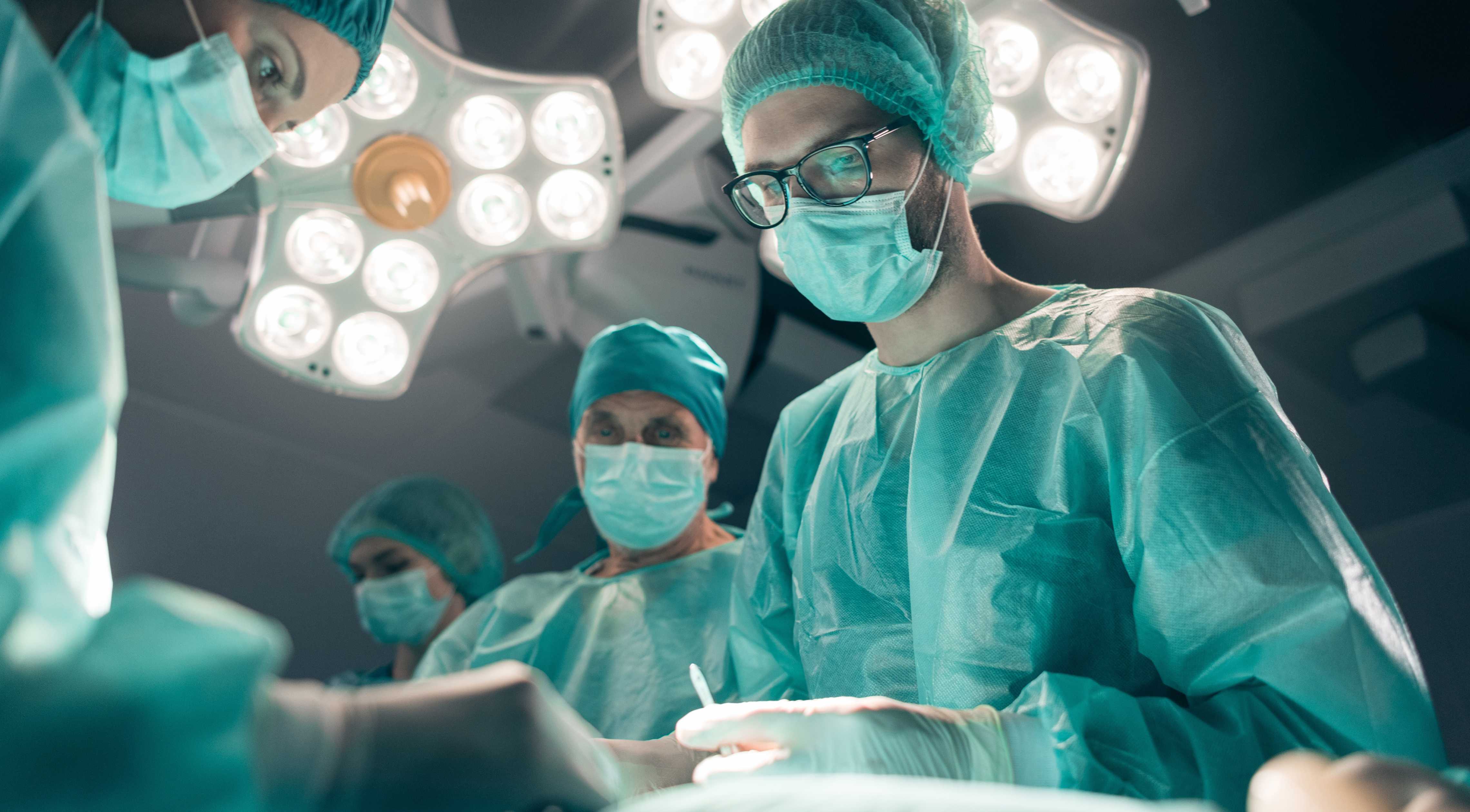 Omslag till fallstudie av UX-design som visar kirurger i operationssalen med lampor över huvudet.